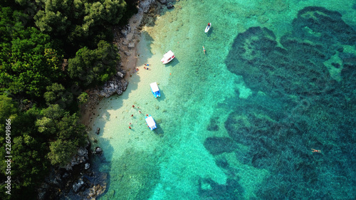 Fototapeta Naklejka Na Ścianę i Meble -  Aerial photo of iconic white cliff tropical bay forming a blue lagoon with deep turquoise clear ocean and docked small boats enjoying this unique paradise