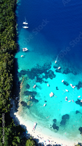 Aerial drone bird s eye view photo of iconic paradise sandy beach of blue lagoon with deep turquoise clear sea and pine trees  in complex island of Mourtos in Sivota area  Epirus  Greece