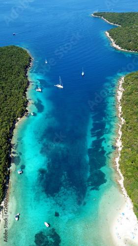 Fototapeta Naklejka Na Ścianę i Meble -  Aerial photo of tropical exotic paradise vegetated island with blue lagoon, white sandy beaches and turquoise sea with sail boats and yachts docked