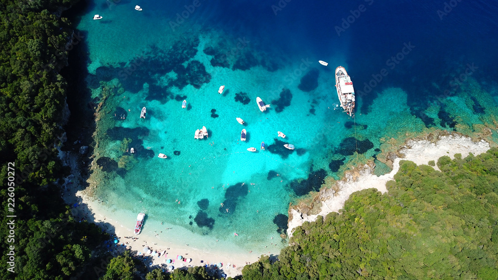 Aerial drone bird's eye view photo of iconic paradise sandy beach of blue lagoon with deep turquoise clear sea and pine trees  in complex island of Mourtos in Sivota area, Epirus, Greece