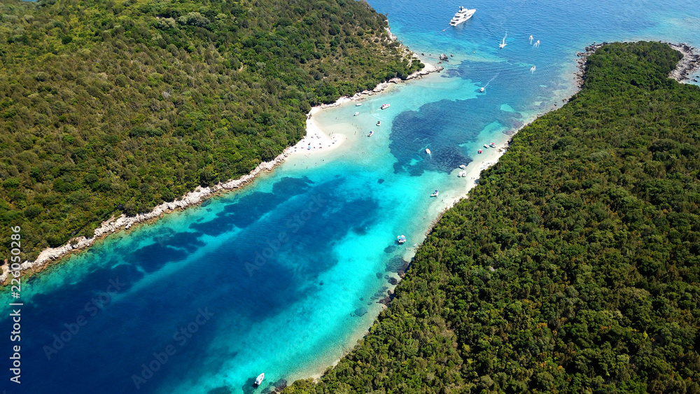 Aerial drone bird's eye view photo of iconic paradise sandy beach of blue lagoon with deep turquoise clear sea and pine trees  in complex island of Mourtos in Sivota area, Epirus, Greece