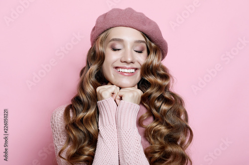 beautiful young female model with long wavy hair wearing pink beret and scarf