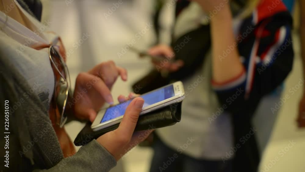 People chating with Mobile Cell Phones in their hands at the bus stop ...