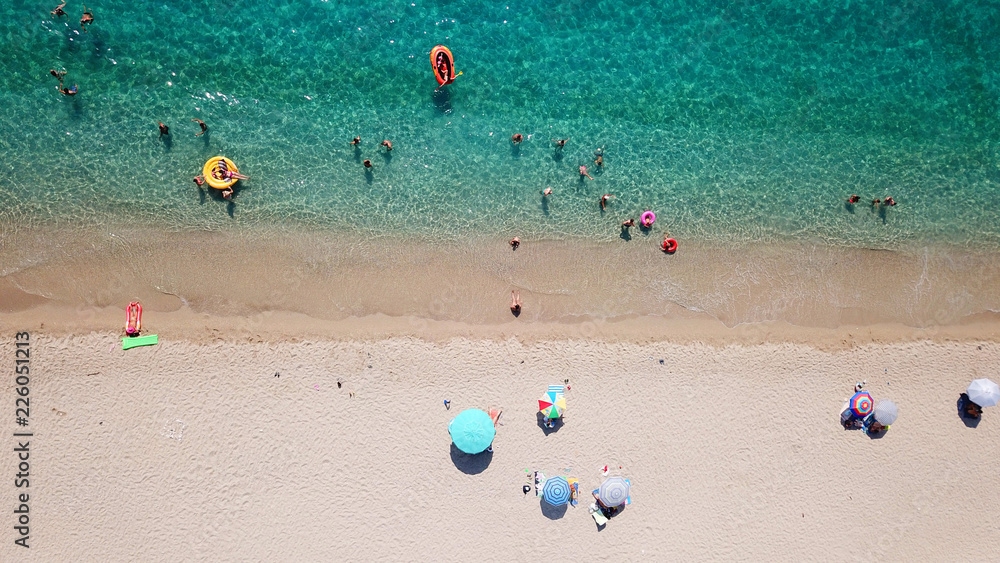 Obraz premium Aerial drone bird's eye view of popular beach of Karavostasi with beautiful clouds and turquoise sandy beach full of sunbeds at summertime, Epirus, Ionian, Greece