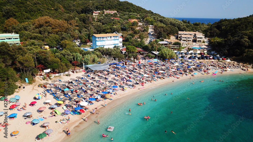 Aerial drone bird's eye view of popular beach of Sarakiniko with beautiful emerald sandy beach full of sunbeds at summer time, Epirus, Ionian, Greece