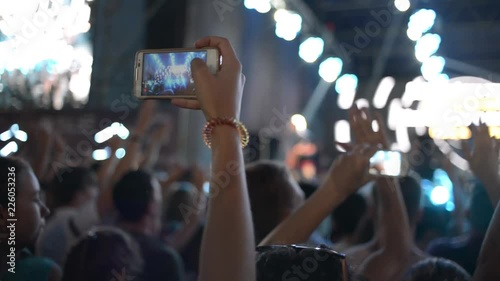 Hands Hold Mobile Camera With Digital Display Among People During Rock Concert