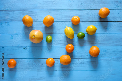 Whole citrus assorty of colourful fruits on the middle of blue wooden textured background. Top view. Copy space. photo