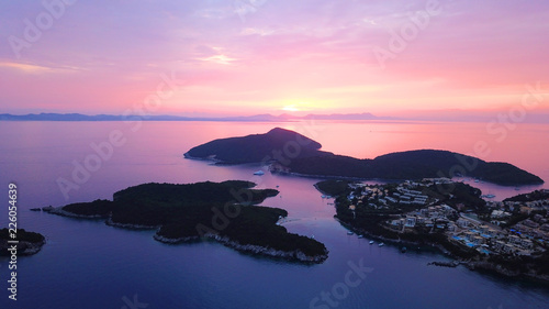 Aerial drone bird's eye view photo of iconic turquoise bay of Sivota forming a blue lagoon with beautiful colours and clouds at sunset, Ionian sea, Epirus, Greece