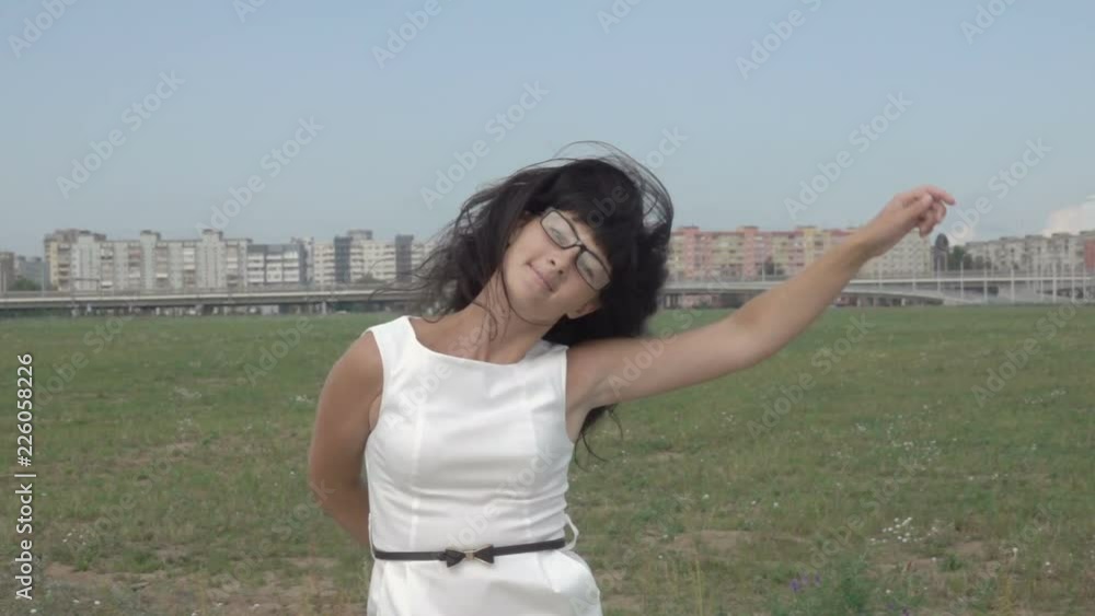 Successful business woman dances and rejoices outdoors on the outskirts of New York City. Funny Businesswoman Dancing. The girl in white dress rejoices. Slow Motion. Successful business woman dances and rejoices outdoors on the outskirts of New York City. Funny Businesswoman Dancing. The girl in white dress rejoices. Slow Motion.