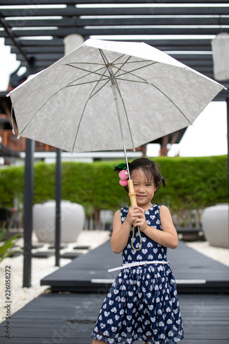 Asian cute girl wearing blue clothes and posing with umbrella