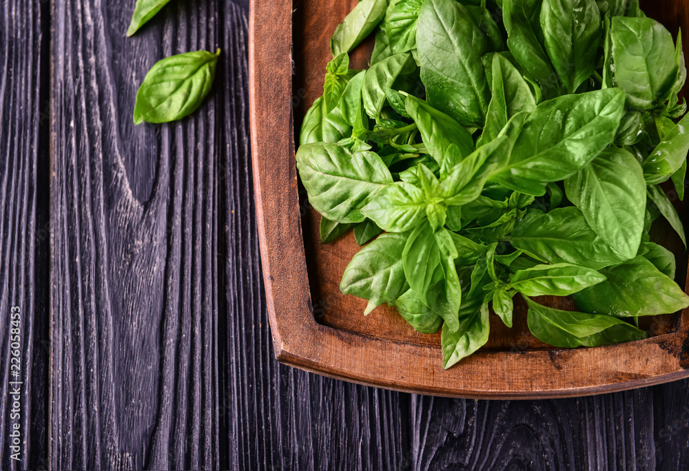 Fresh green basil on wooden board
