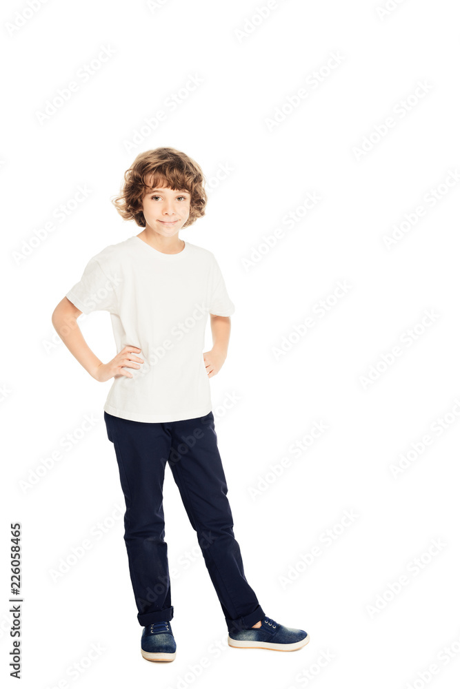 smiling adorable boy standing with hands akimbo and looking at camera isolated on white smiling adorable boy standing with hands akimbo and looking at camera isolated on white