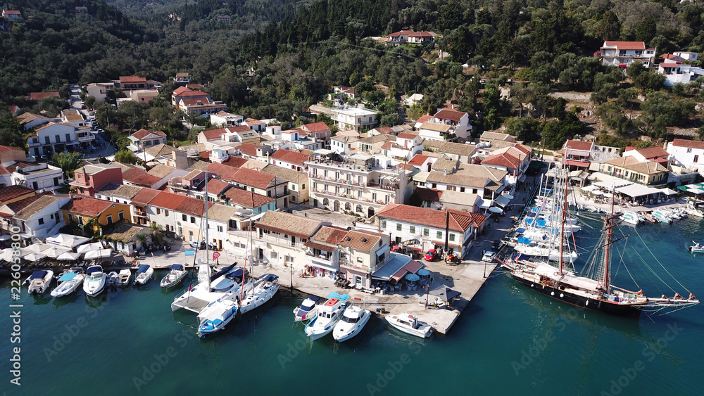 Aerial drone bird's eye view photo of iconic small port and fishing village of Lakka with traditional Ionian architecture and sail boats docked, Paxos island, Ionian, Greece