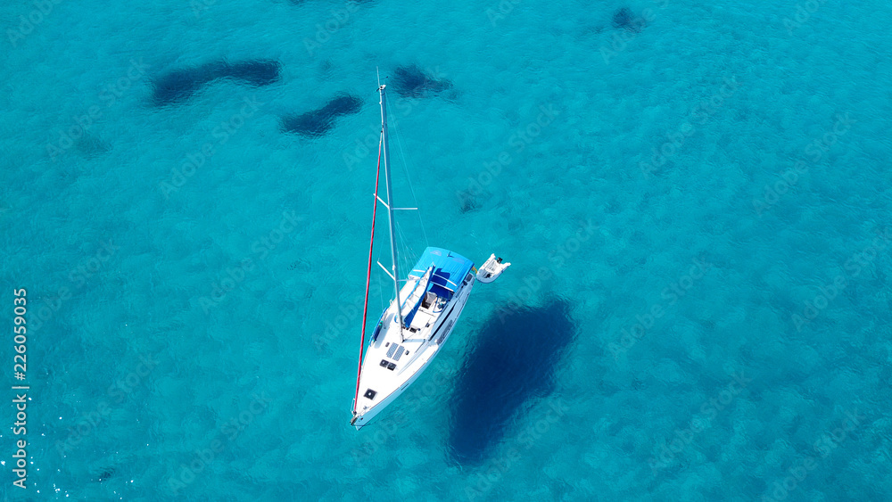 Aerial drone top view photo of luxury sail boats docked in tropical bay with turquoise and emerald clear sea