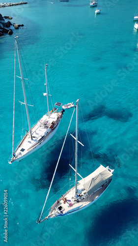Aerial drone top view photo of luxury sail boats docked in tropical bay with turquoise and emerald clear sea