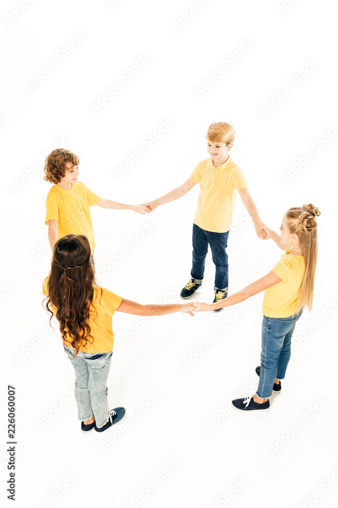 high angle view of cute happy kids standing together and holding hands isolated on white high angle view of cute happy kids standing together and holding hands isolated on white