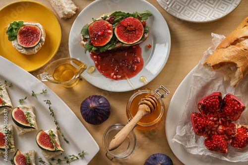 Tasty sandwiches with ripe fig and honey on wooden table