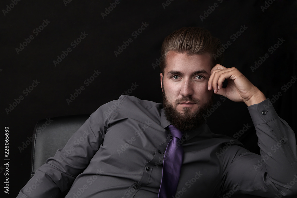 Portrait eines jungen  Geschäftsmannes vor schwarzen Hintergrund