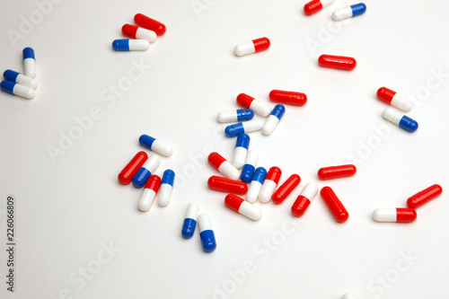 red and blue pills on white background photo