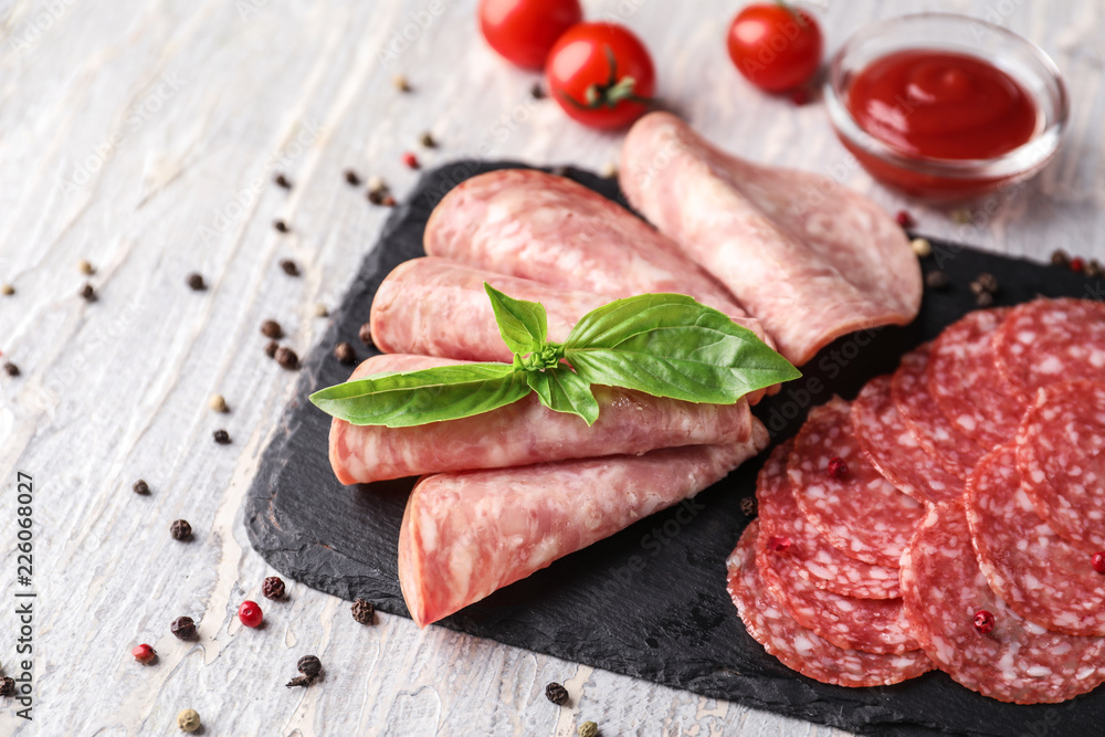 Slate plate with different kinds of sausages on light table Slate plate with different kinds of sausages on light table