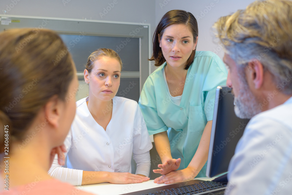 Fototapeta premium Medical workers in discussion with middle aged couple