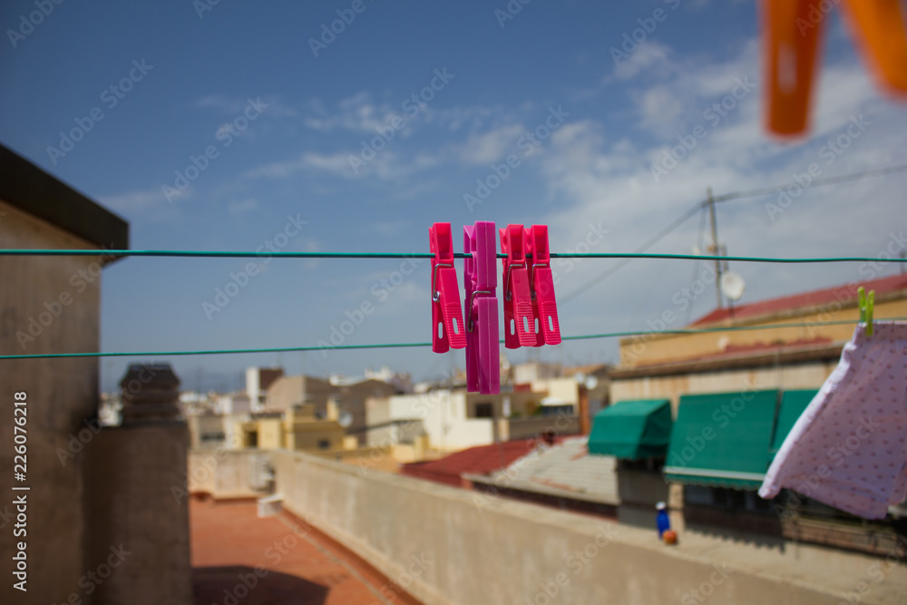colorful clothespin on a rope against the background of the sky 