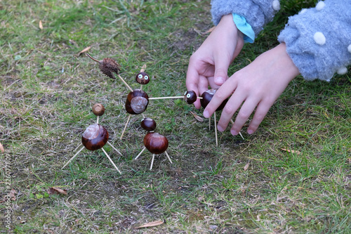 Kinderhände basteln Figuren mit Kastanien