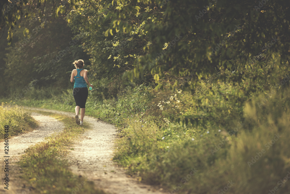 woman jogging along a country road woman jogging along a country road