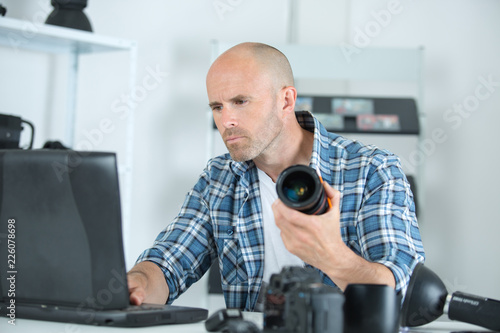 man repairing dslr lense looking up on internet for help