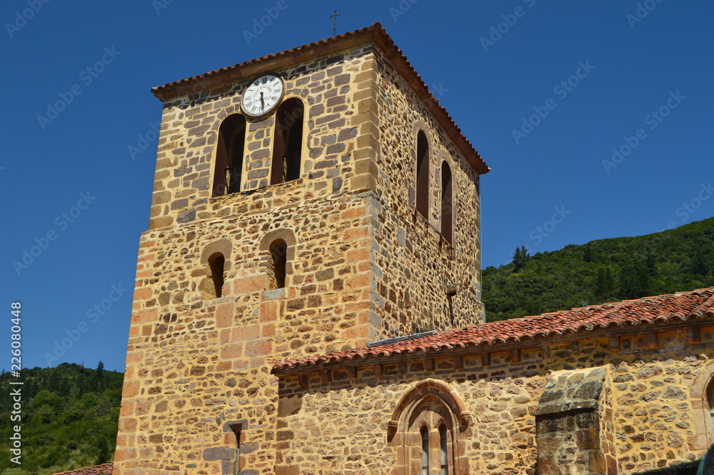 Clock Tower Of The Old Church Of San Vicente In Pots Dated From Medieval Times In Villa De Potes. Nature, Architecture, History, Travel. July 30, 2018.Potes, Cantabria, Spain