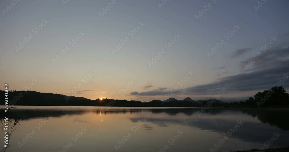 Beautiful timelapse of sunrise sky above a scenic lake. Time lapse of a white swan swimmming over Lake at sunrise. Beautiful timelapse of sunrise sky above a scenic lake. Time lapse of a white swan swimmming over Lake at sunrise.