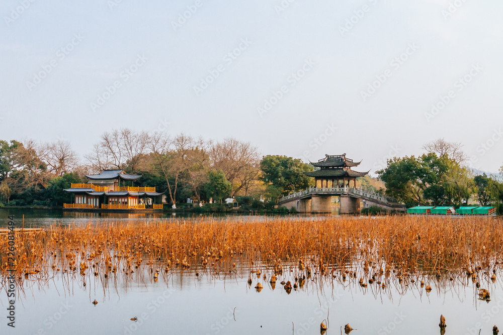 Chinese pavilions and stone bridge over water in Hangzhou