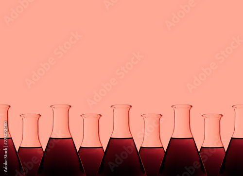 Row of test tubes with liquid, red background photo