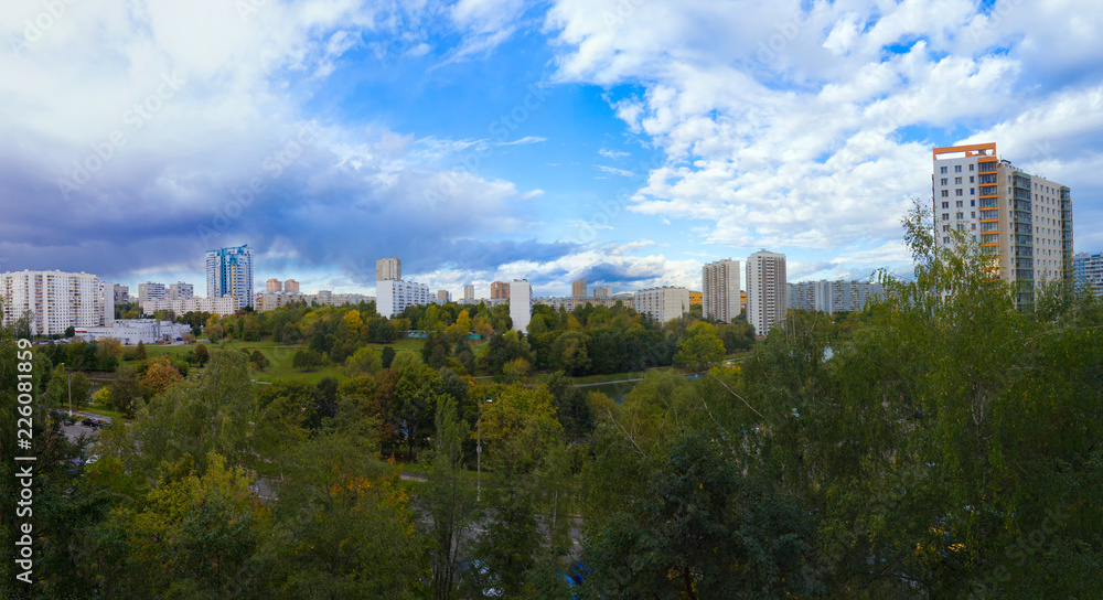 Panorama residential disctrict of Moscow with beautiful clouds in the blue sky, soviet houses, a large park – panoramic view of the city in high resolution, early autumn