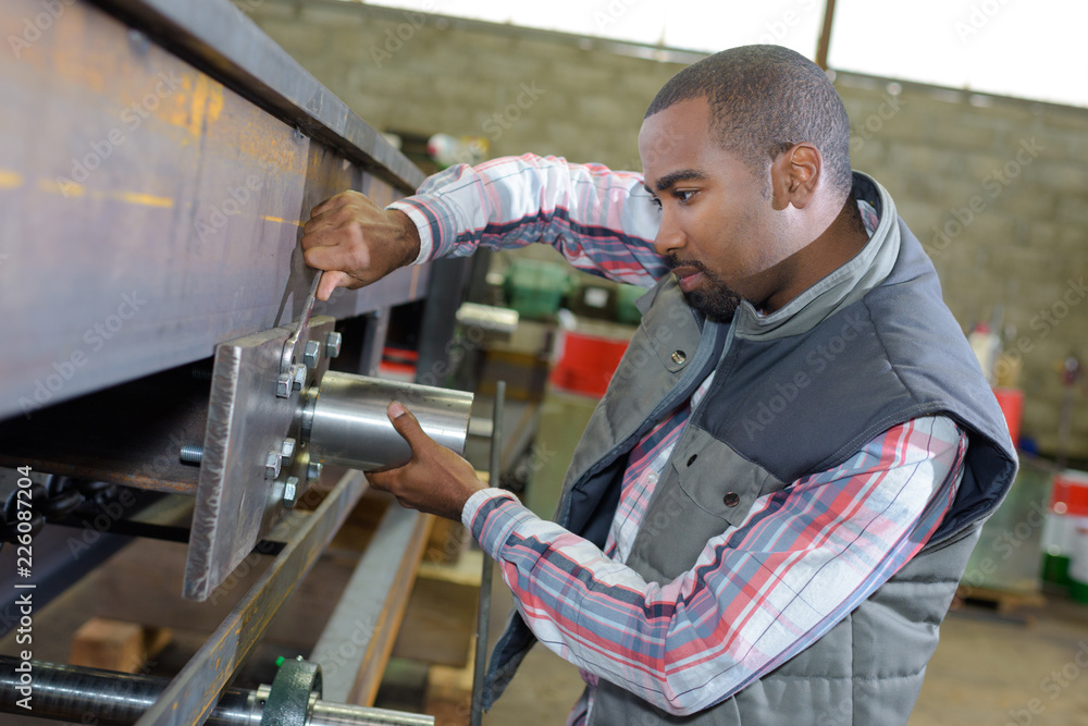 Man adjusting machine with spanner Man adjusting machine with spanner