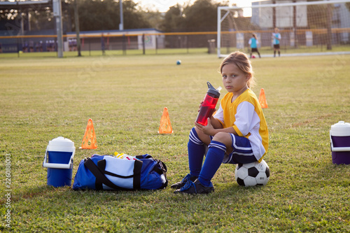 A soccer player takes a break for water. 