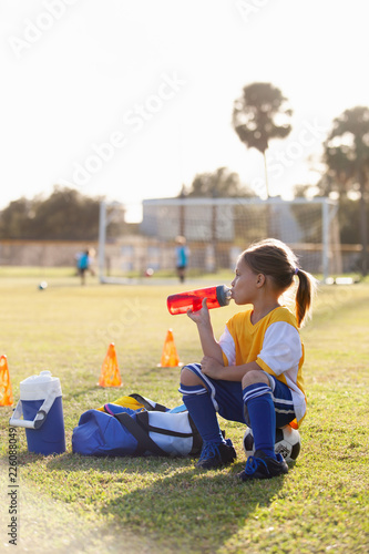 A soccer player takes a break for water. 