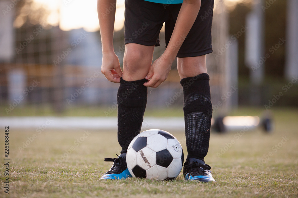 A soccer player adjusting his socks. A soccer player adjusting his socks.