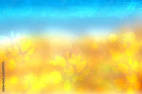 Abstract autumn or bright summer landscape texture with yellow leaves and blue bright sky. Autumn or summer background with copy space.