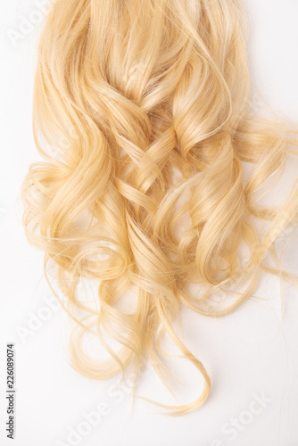 Human, natural light blond wavy hair on white isolated background. An example of a fashionable hairstyle for a poster, an advertisement or a hairdressing website.