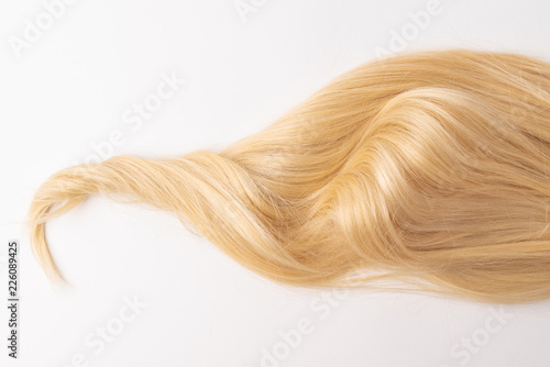 Human, natural light blond wavy hair on white isolated background. An example of a fashionable hairstyle for a poster, an advertisement or a hairdressing website.