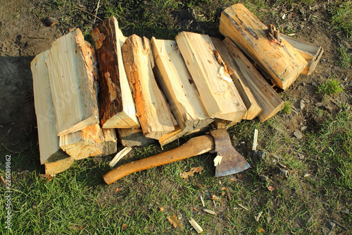 Firewood for fire and ax on the ground. Close-up. Background.