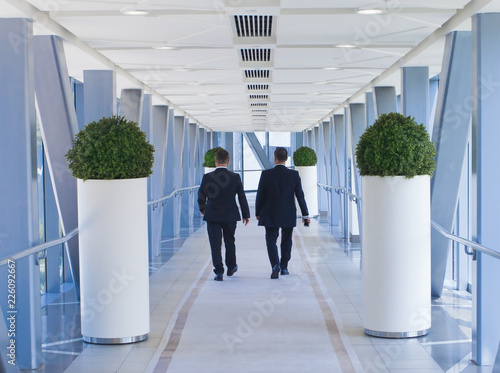 two business men people walking in modern building, vision or success concept