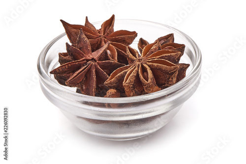 Anise star, badian spice in a glass bowl, close-up, isolated on a white background.
