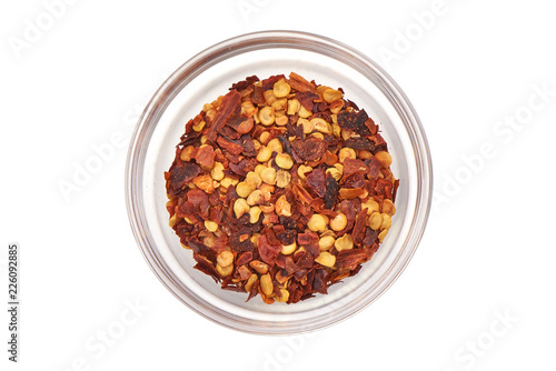 Red chili flakes, ground spice hot pepper, isolated on white background. Top view.