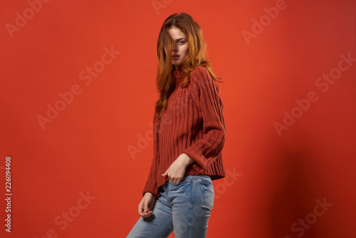 beautiful woman in a sweater on a red background