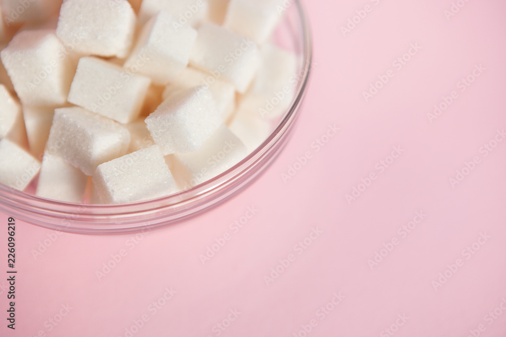 White sugar cubes in glass bowl on pink with copy space, sweet food background White sugar cubes in glass bowl on pink with copy space, sweet food background