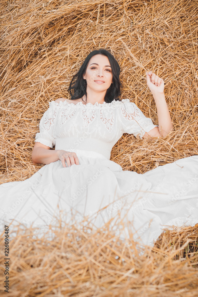 Beautiful young woman on the dried haystack Beautiful young woman on the dried haystack