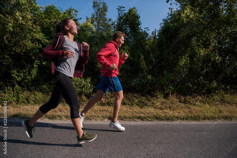 Fototapeta premium young couple jogging along a country road