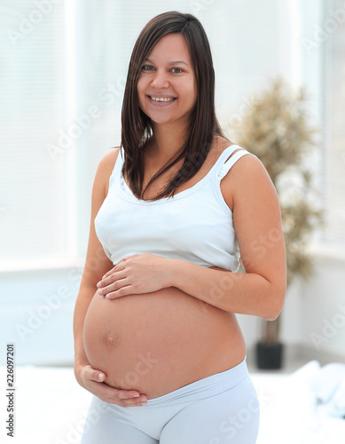 portrait of young pregnant woman on a light background. Free Download portrait of young pregnant woman on a light background. - GFXLoad